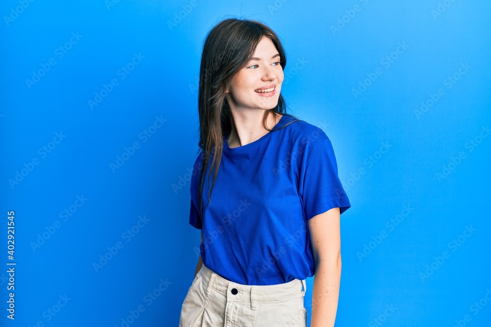 Young beautiful caucasian girl wearing casual clothes looking to side, relax profile pose with natural face and confident smile. Young beautiful caucasian girl wearing casual clothes looking to side, relax profile pose with natural face and confident smile.