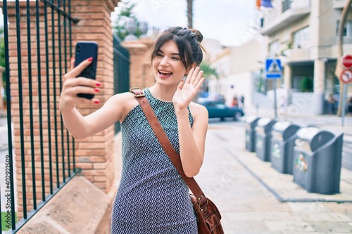 Young caucasian businesswoman smiling happy doing video call using smartphone at the city.