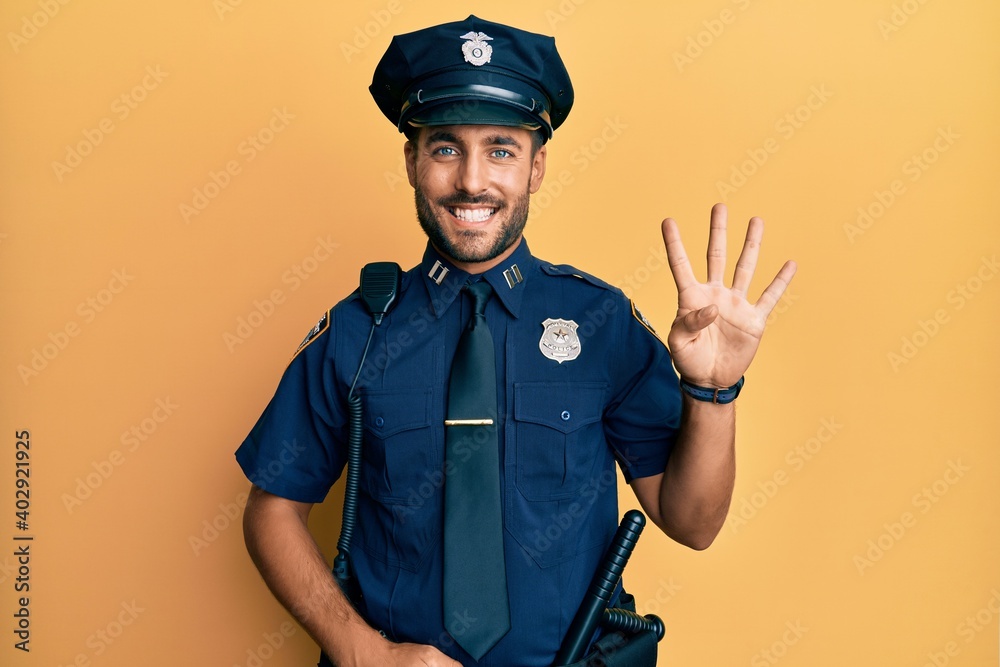 Handsome hispanic man wearing police uniform showing and pointing up with fingers number four while smiling confident and happy.