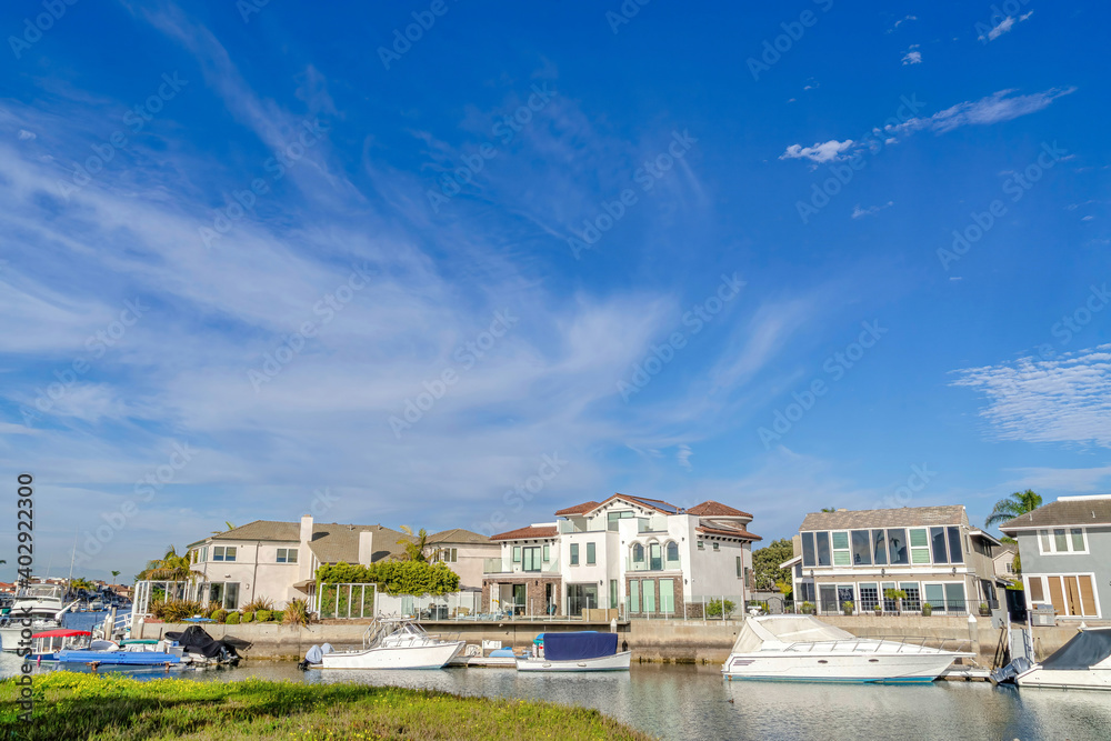 Serene blue sky over houses overlooking boats at the harbor in Huntington Beach