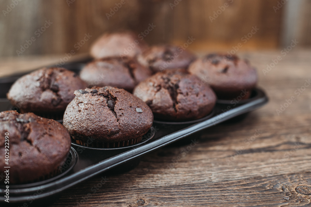 Top view of homemade freshly baked chocolate muffins, keks or cupcakes on wooden table with place for text. Bakery, bakery, bakery. Top view of homemade freshly baked chocolate muffins, keks or cupcakes on wooden table with place for text. Bakery, bakery, bakery.