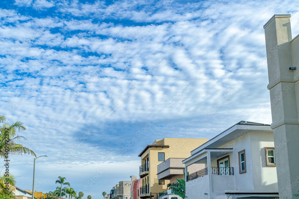 Obraz premium Blue sky and puffy clouds in coastal neighborhood of Huntington Beach California