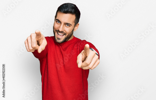 Young hispanic man wearing casual clothes pointing to you and the camera with fingers, smiling positive and cheerful photo