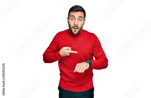 Young hispanic man wearing casual clothes in hurry pointing to watch time, impatience, upset and angry for deadline delay