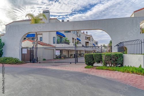 Gated entrance at a neighborhood in Huntington Beach under cloudy blue sky
