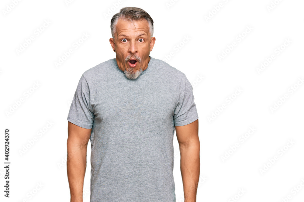 Fototapeta premium Middle age grey-haired man wearing casual clothes scared and amazed with open mouth for surprise, disbelief face