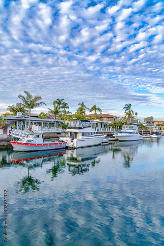 Vivid blue sky with clouds reflected on the sea with private docks and boats