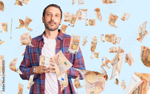 Young handsome man wearing casual clothes hands together and fingers crossed smiling relaxed and cheerful. success and optimistic photo