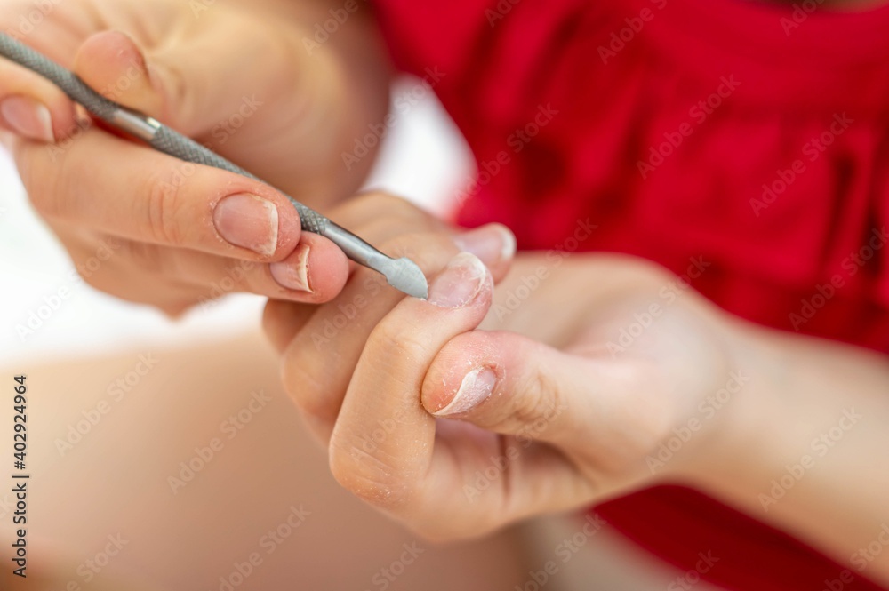 Woman's hands filing her nails with a red blouse. Woman's hands filing her nails with a red blouse.