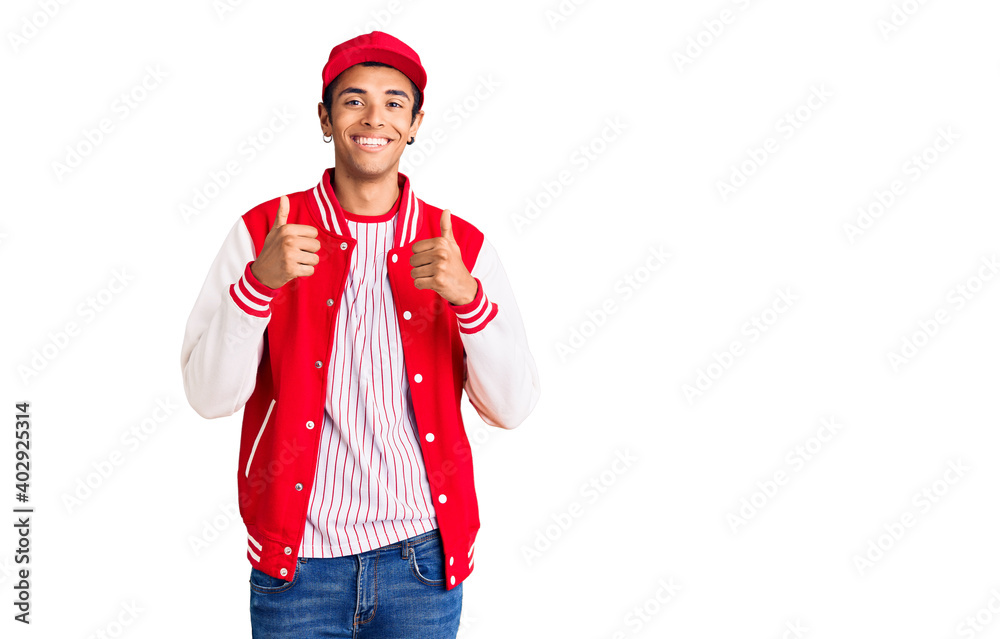 Young african amercian man wearing baseball uniform success sign doing positive gesture with hand, thumbs up smiling and happy. cheerful expression and winner gesture.
