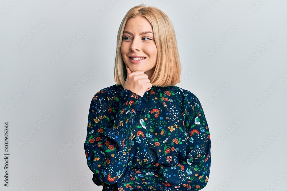 Young blonde woman wearing casual clothes with hand on chin thinking about question, pensive expression. smiling with thoughtful face. doubt concept. Young blonde woman wearing casual clothes with hand on chin thinking about question, pensive expression. smiling with thoughtful face. doubt concept.