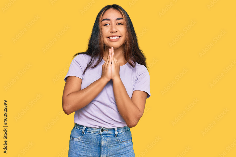 Young latin woman wearing casual clothes praying with hands together asking for forgiveness smiling confident. Young latin woman wearing casual clothes praying with hands together asking for forgiveness smiling confident.