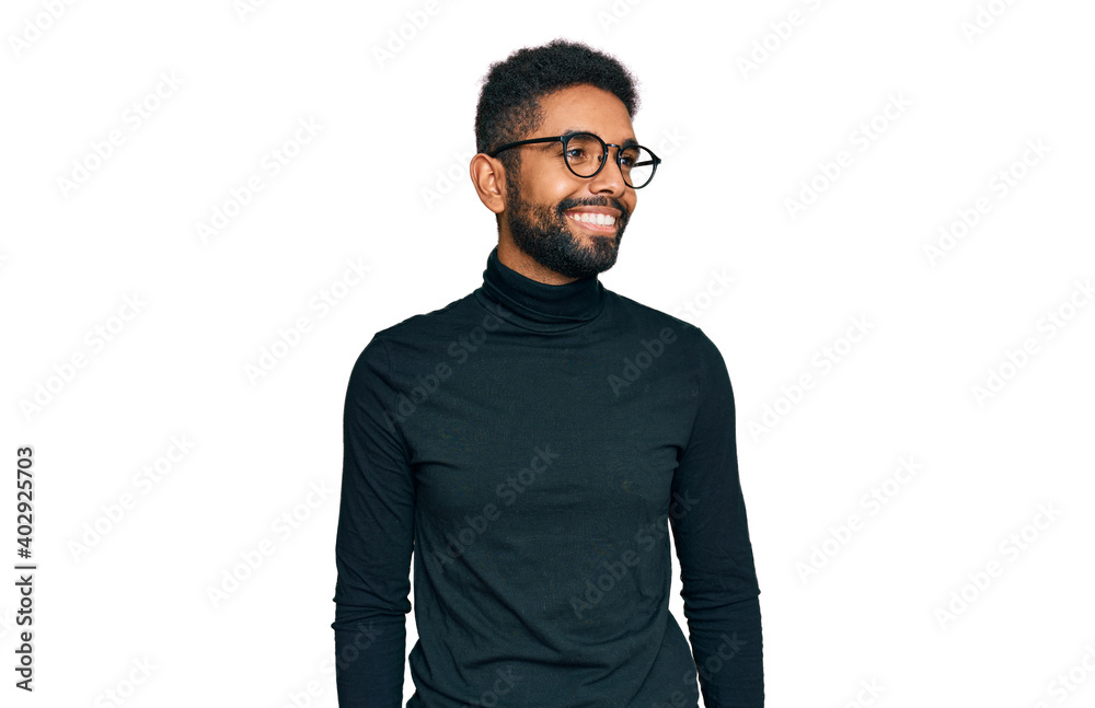 Fototapeta premium Young african american man wearing casual clothes looking away to side with smile on face, natural expression. laughing confident.