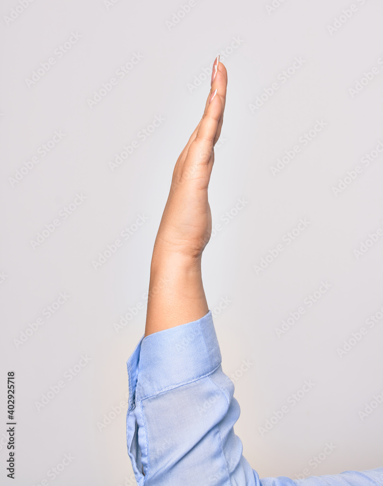 Hand of caucasian young woman with opened palm and streched finger raised up over isolated white background