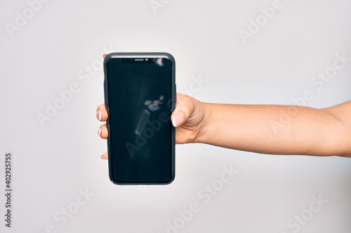 Hand of caucasian young woman holding smartphone showing screen over isolated white background