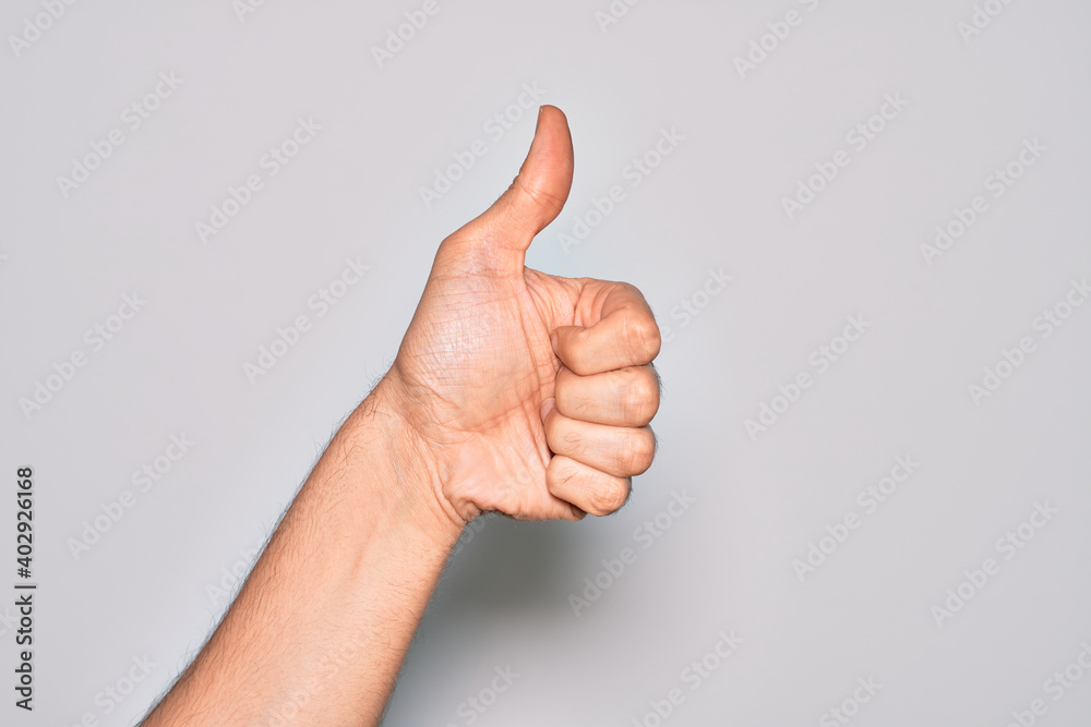 Hand of caucasian young man showing fingers over isolated white background doing successful approval gesture with thumbs up, validation and positive symbol