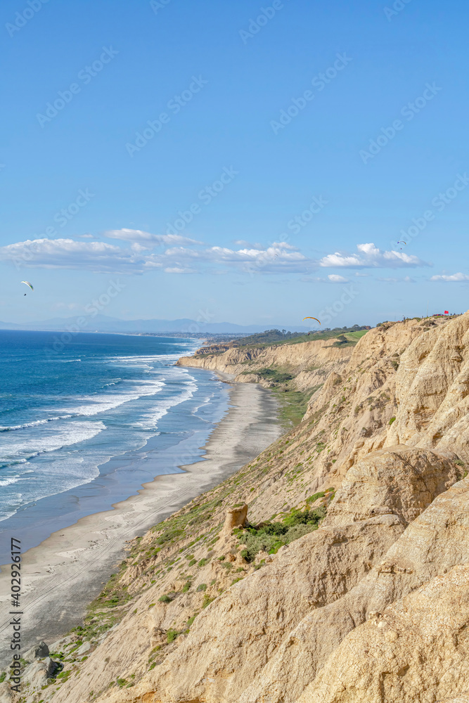 Scenic nature landscape of blue ocean with shoreline bordered by rocky mountain