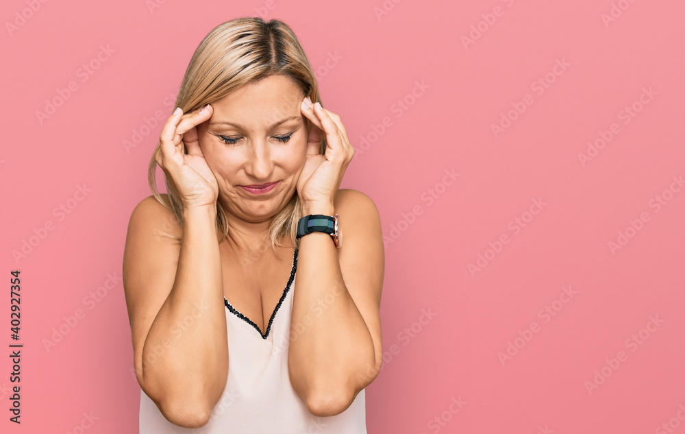 Middle age caucasian woman wearing casual clothes with hand on head, headache because stress. suffering migraine. Middle age caucasian woman wearing casual clothes with hand on head, headache because stress. suffering migraine.