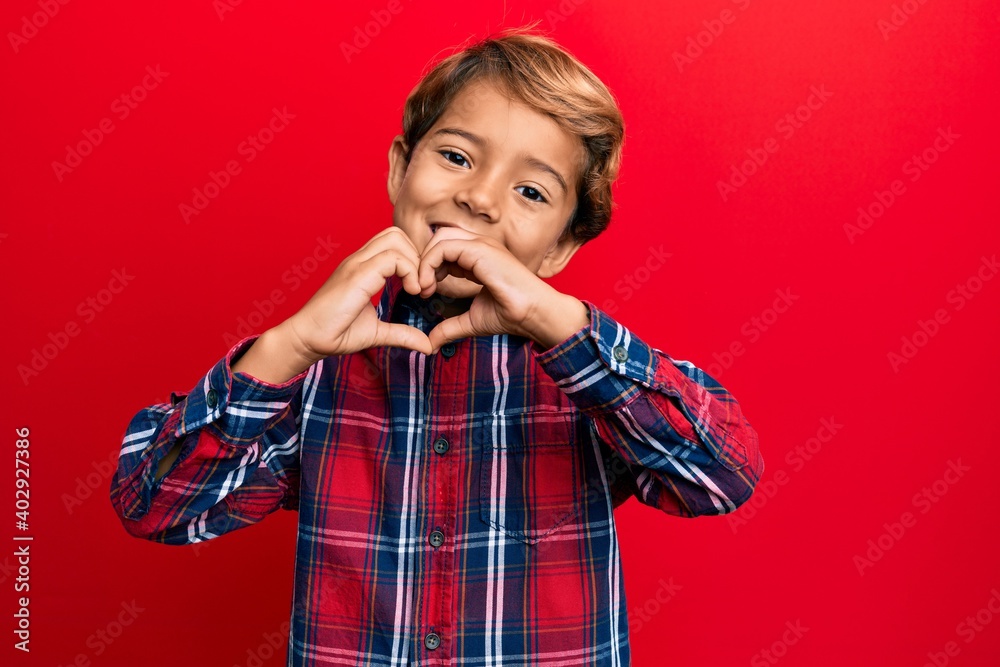 Adorable latin kid wearing casual clothes smiling in love doing heart symbol shape with hands. romantic concept. Adorable latin kid wearing casual clothes smiling in love doing heart symbol shape with hands. romantic concept.