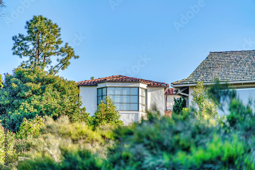 Home exterior with bay window against blue sky and green foliage on a sunny day