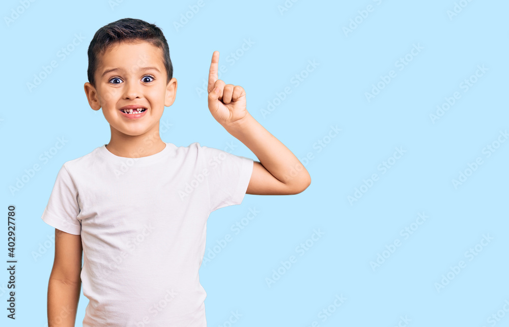 Little cute boy kid wearing casual white tshirt pointing finger up with successful idea. exited and happy. number one. Little cute boy kid wearing casual white tshirt pointing finger up with successful idea. exited and happy. number one.