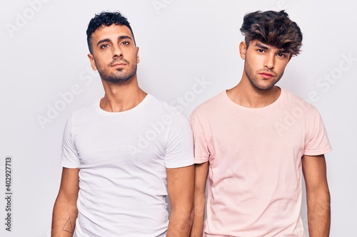 Young gay couple wearing casual clothes relaxed with serious expression on face. simple and natural looking at the camera.