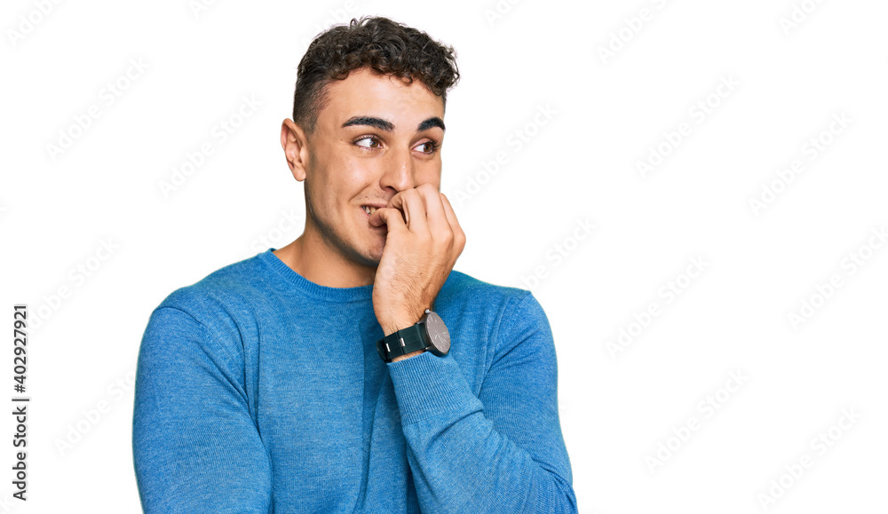 Hispanic young man wearing casual clothes looking stressed and nervous with hands on mouth biting nails. anxiety problem. Hispanic young man wearing casual clothes looking stressed and nervous with hands on mouth biting nails. anxiety problem.