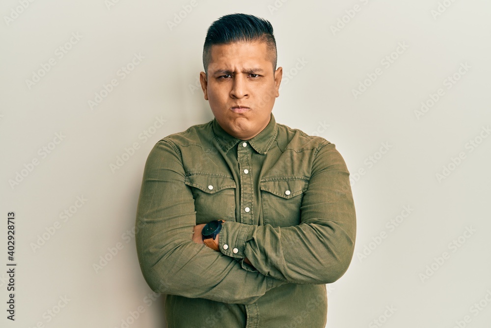 Young latin man wearing casual clothes skeptic and nervous, disapproving expression on face with crossed arms. negative person. Young latin man wearing casual clothes skeptic and nervous, disapproving expression on face with crossed arms. negative person.