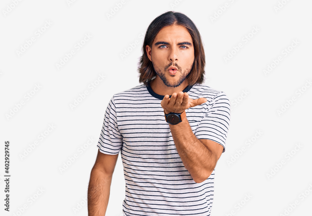 Young handsome man wearing casual clothes looking at the camera blowing a kiss with hand on air being lovely and sexy. love expression. Young handsome man wearing casual clothes looking at the camera blowing a kiss with hand on air being lovely and sexy. love expression.