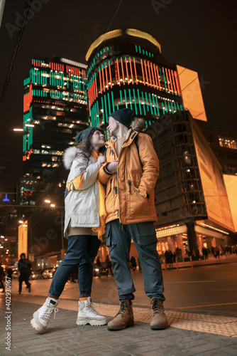 Happy cheerful and young caucasian couple are having fun while dating together outdoors in a city