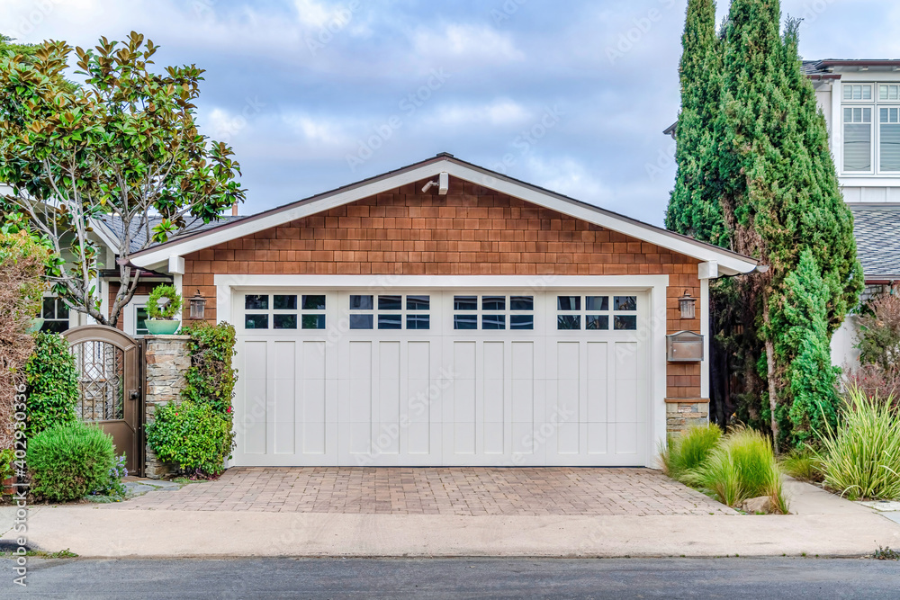 Garage in San Diego California with white door and brown wall under gable roof Garage in San Diego California with white door and brown wall under gable roof
