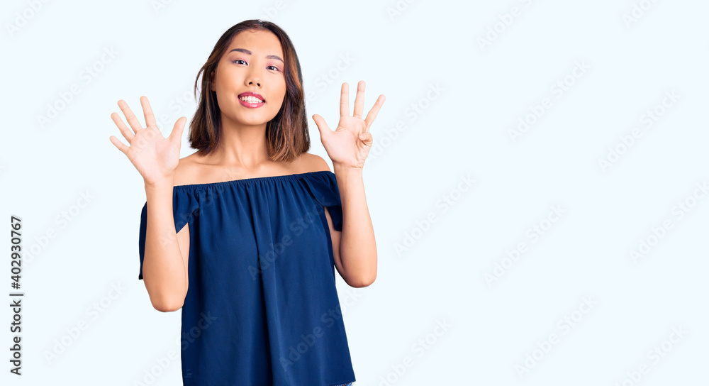 Young beautiful chinese girl wearing casual clothes showing and pointing up with fingers number nine while smiling confident and happy. Young beautiful chinese girl wearing casual clothes showing and pointing up with fingers number nine while smiling confident and happy.