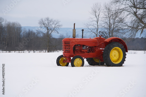 A red tractor in a snow filled farmers field