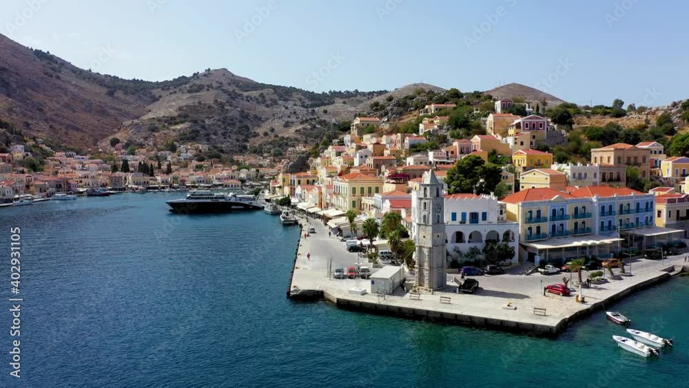 View on Symi (Simi) island harbor port, classical ship yachts, houses on island hills, Aegean Sea bay. Greece islands holidays vacation travel tours from Rhodos island. Symi, Greece, Dodecanese. View on Symi (Simi) island harbor port, classical ship yachts, houses on island hills, Aegean Sea bay. Greece islands holidays vacation travel tours from Rhodos island. Symi, Greece, Dodecanese.