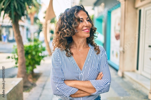 Middle age hispanic woman smiling happy walking at the city.