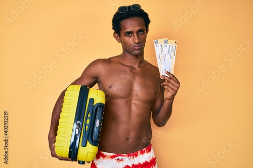African handsome man going on summer trip holding boarding pass skeptic and nervous, frowning upset because of problem. negative person.
