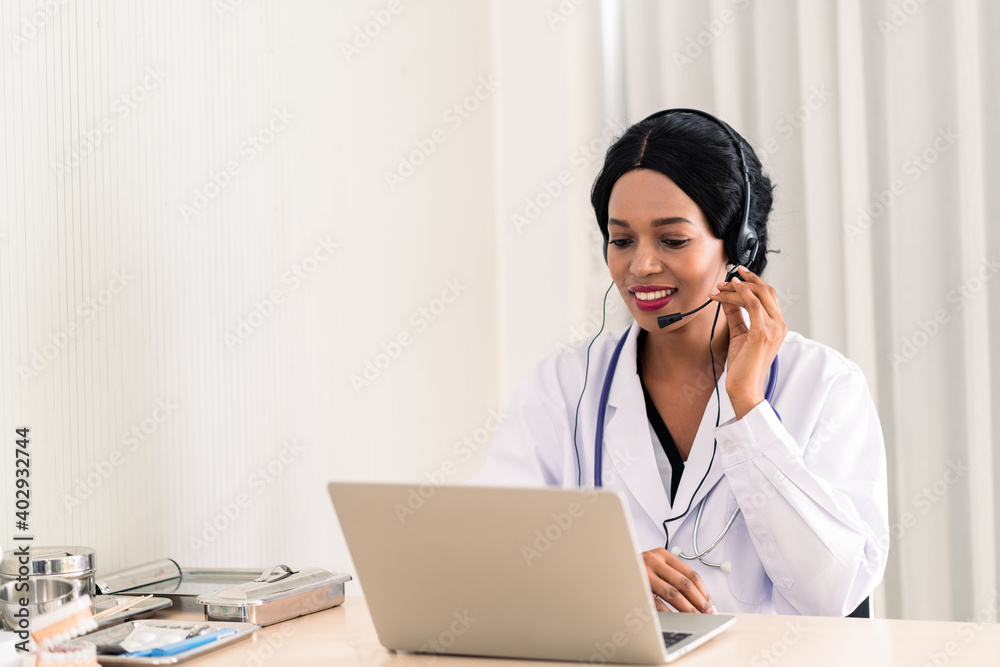 african woman doctor in headset taking calling on her headset microphone online for a ache patient african woman doctor in headset taking calling on her headset microphone online for a ache patient