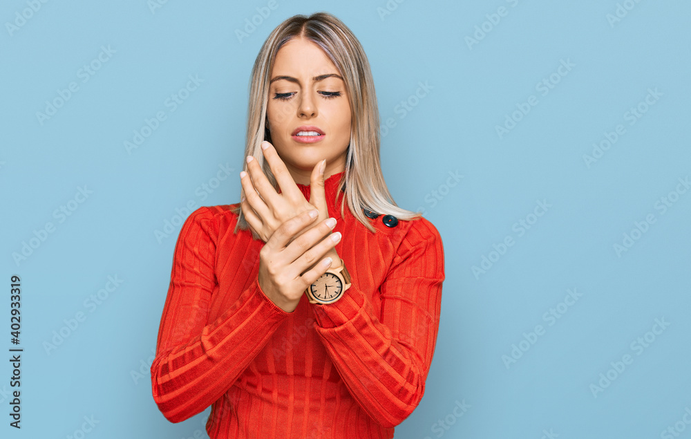 Beautiful blonde woman wearing casual clothes suffering pain on hands and fingers, arthritis inflammation