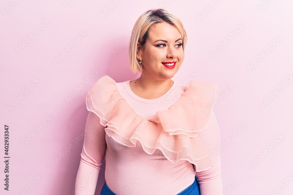 Young beautiful blonde plus size woman wearing casual sweater over isolated pink background looking to side, relax profile pose with natural face and confident smile. Young beautiful blonde plus size woman wearing casual sweater over isolated pink background looking to side, relax profile pose with natural face and confident smile.