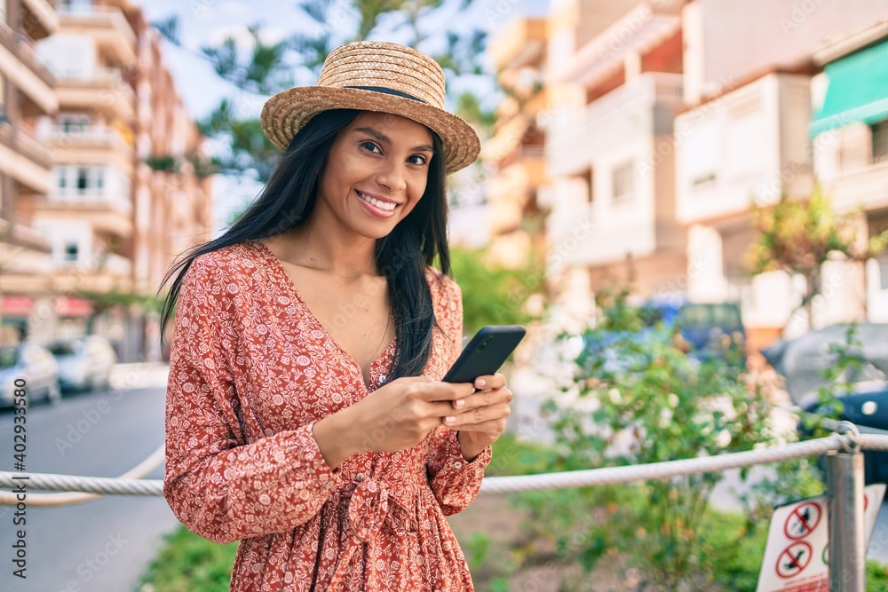 Young african american tourist woman on vacation smiling happy using smartphone at the city.