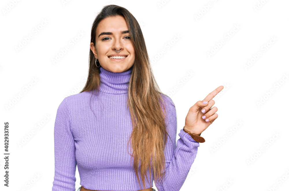 Young hispanic woman wearing casual clothes with a big smile on face, pointing with hand finger to the side looking at the camera. Young hispanic woman wearing casual clothes with a big smile on face, pointing with hand finger to the side looking at the camera.