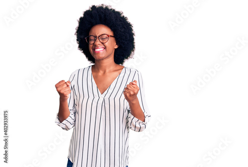 Young african american woman wearing casual clothes and glasses excited for success with arms raised and eyes closed celebrating victory smiling. winner concept.