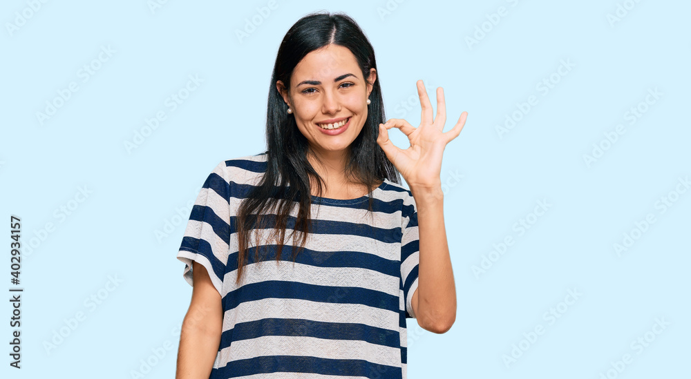 Beautiful young woman wearing casual clothes smiling positive doing ok sign with hand and fingers. successful expression. Beautiful young woman wearing casual clothes smiling positive doing ok sign with hand and fingers. successful expression.