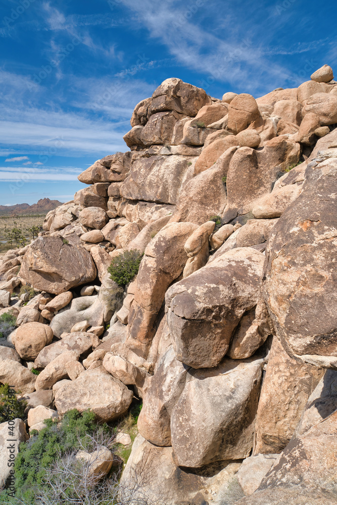 Sunlit rocks forming mountains against blue sky at Joshua Tree National Park