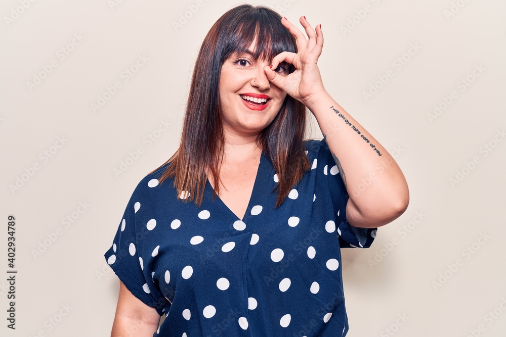 Young plus size woman wearing casual clothes smiling happy doing ok sign with hand on eye looking through fingers Young plus size woman wearing casual clothes smiling happy doing ok sign with hand on eye looking through fingers