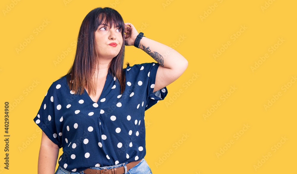 Young plus size woman wearing casual clothes confuse and wondering about question. uncertain with doubt, thinking with hand on head. pensive concept. Young plus size woman wearing casual clothes confuse and wondering about question. uncertain with doubt, thinking with hand on head. pensive concept.