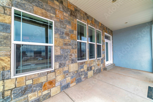 Stone brick wall windows and front door at the facade of a residential house