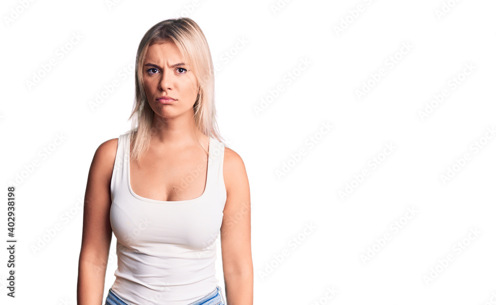 Young beautiful blonde woman wearing casual sleeveless t-shirt skeptic and nervous, frowning upset because of problem. negative person. Young beautiful blonde woman wearing casual sleeveless t-shirt skeptic and nervous, frowning upset because of problem. negative person.