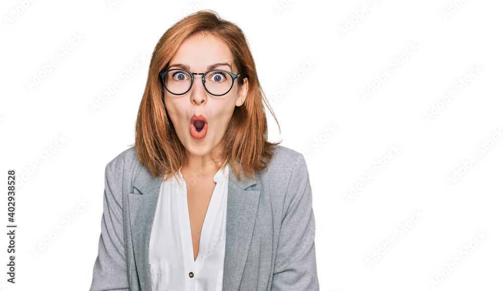 Young caucasian woman wearing business style and glasses afraid and shocked with surprise and amazed expression, fear and excited face.
