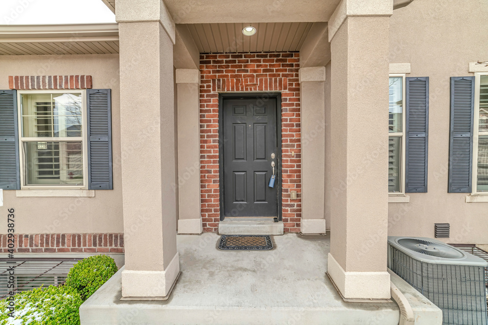House entrance with portico leading to front door against red brick wall House entrance with portico leading to front door against red brick wall